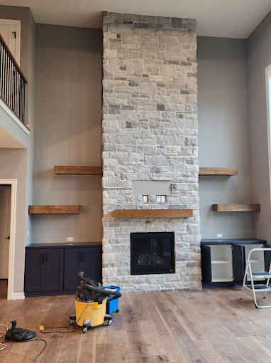 A living room with a fireplace and some shelves